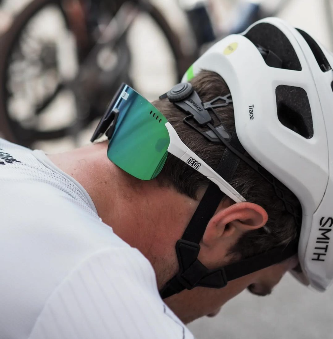 Man in a white cycling helmet wearing green mirrored NEON sport glasses